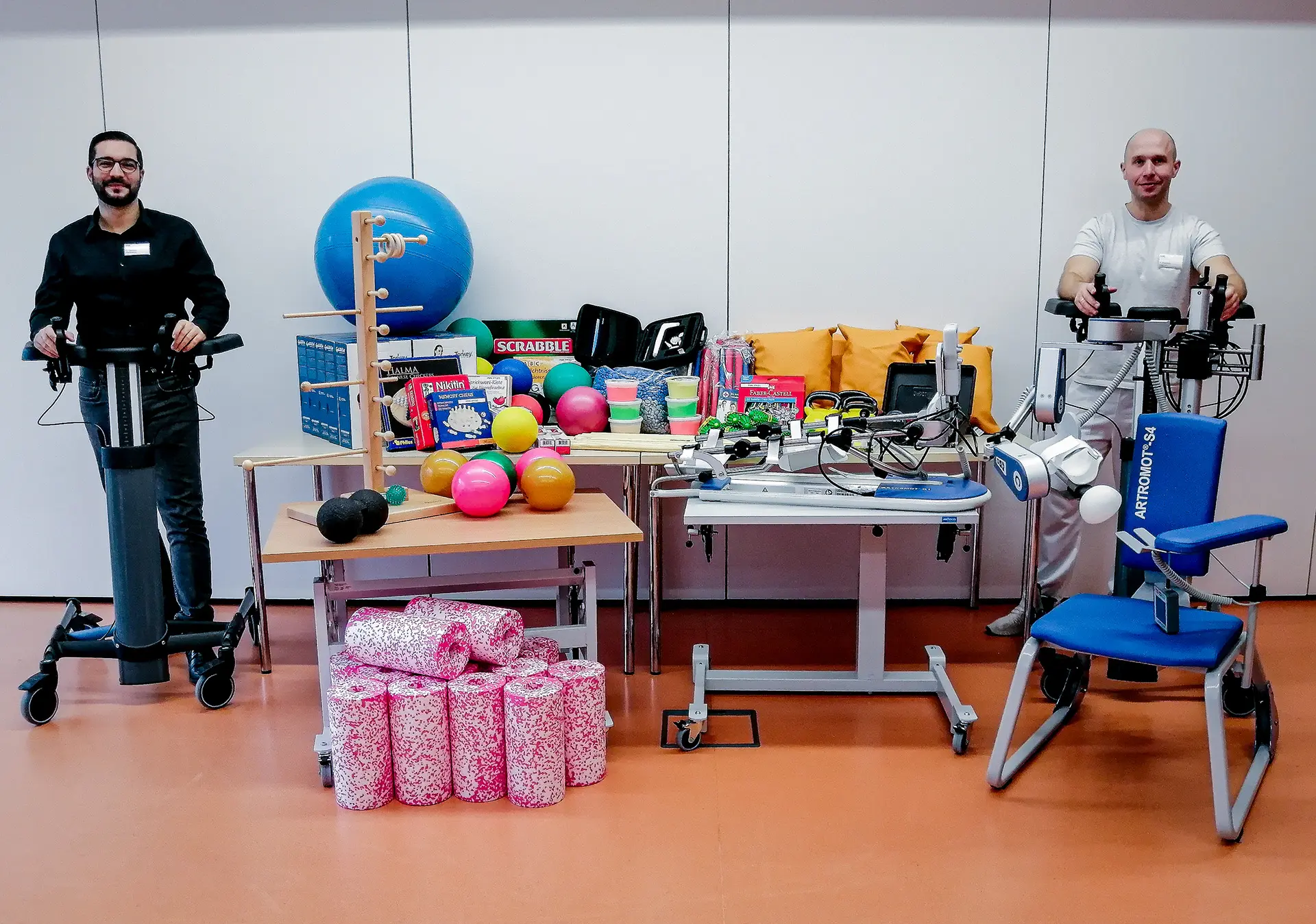 Der Leiter des Pflegedienstes, Giancarlo Cannavo und der Leiter des therapeutischen Teams, Adrian Wosnitza, der Rems-Murr-Klinik Schorndorf mit den Geräten und Hilfsmitteln, die mit der Spende des Vereins der Freunde der Rems-Murr-Klinik Schorndorf angeschafft werden konnten