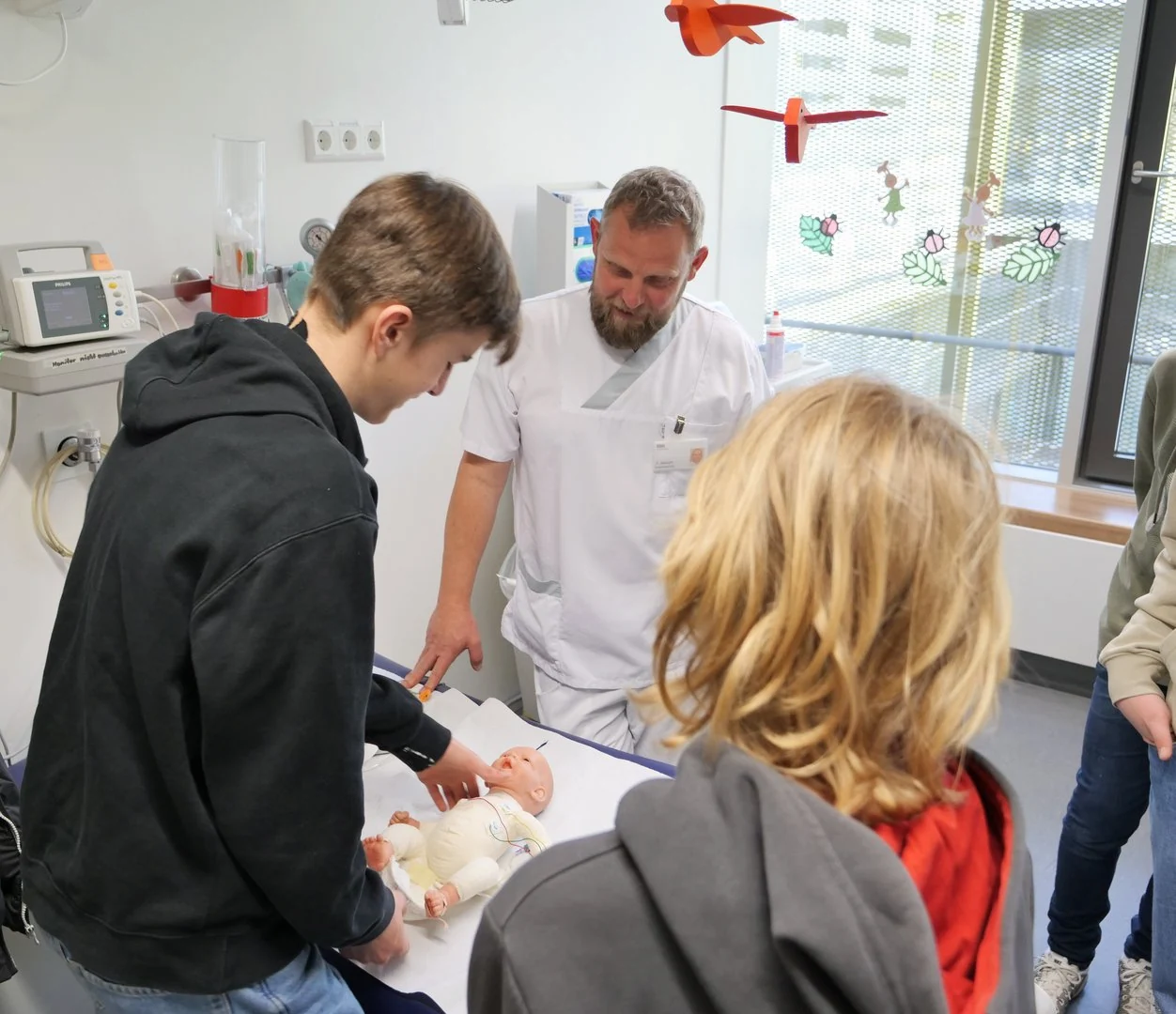 Ben und David üben Babywickeln, Peter Albrecht gibt Acht