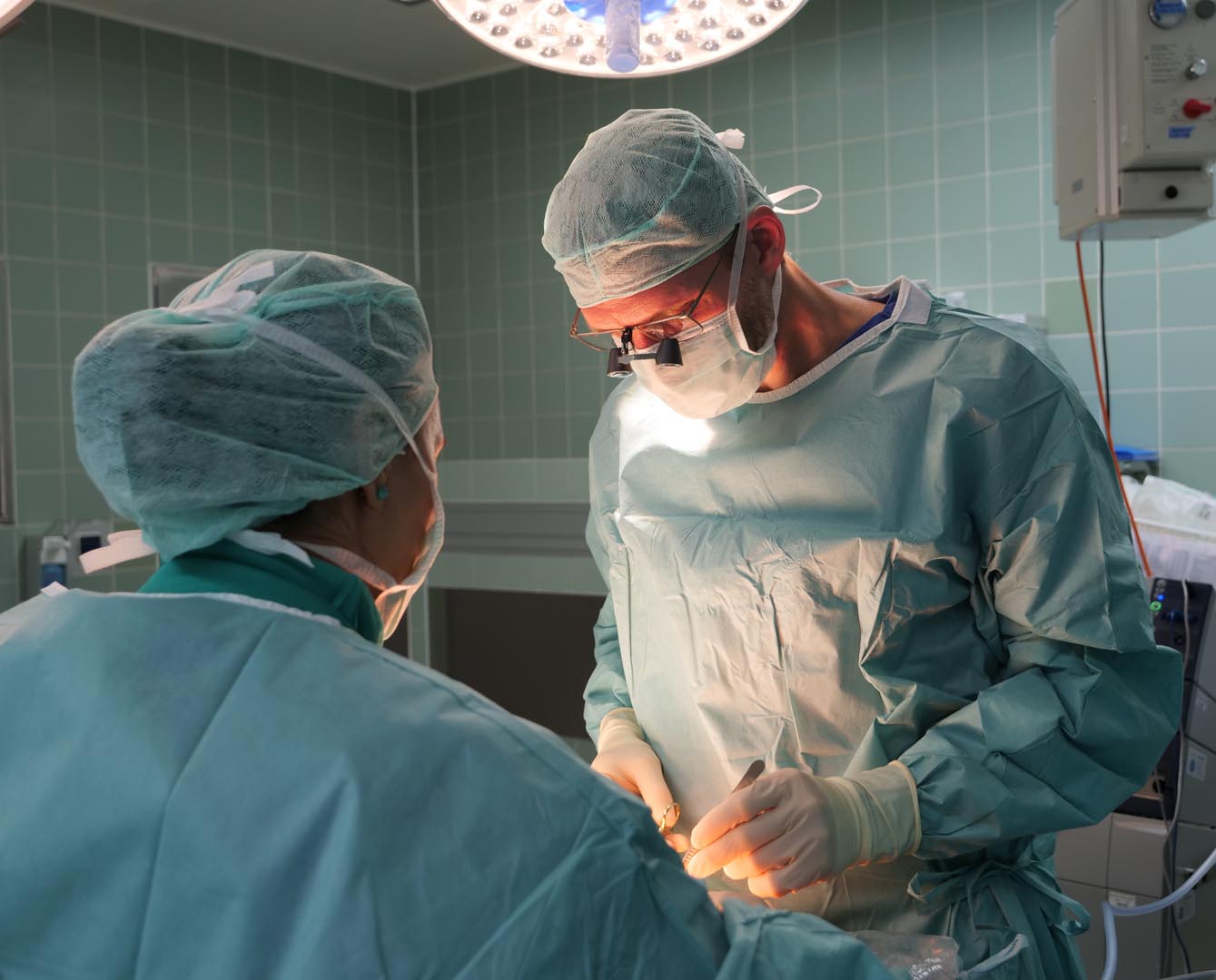 Chefarzt Dr. Christoph Ulmer bei einer OP an feinen Strukturen mit Lupenbrille