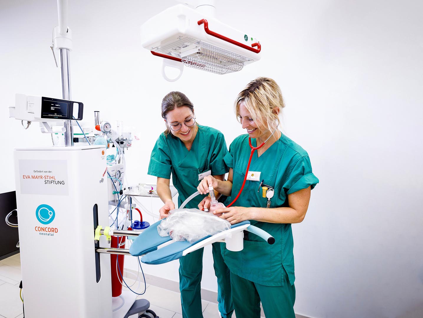 Die Erstversorgungseinheit „Concord neonatal“ ist mit Wärmestrahler, Absaugeinheit und Überwachungsmonitor bestückt. Dr. Janaina Rauch (rechts) demonstriert die Funktion
