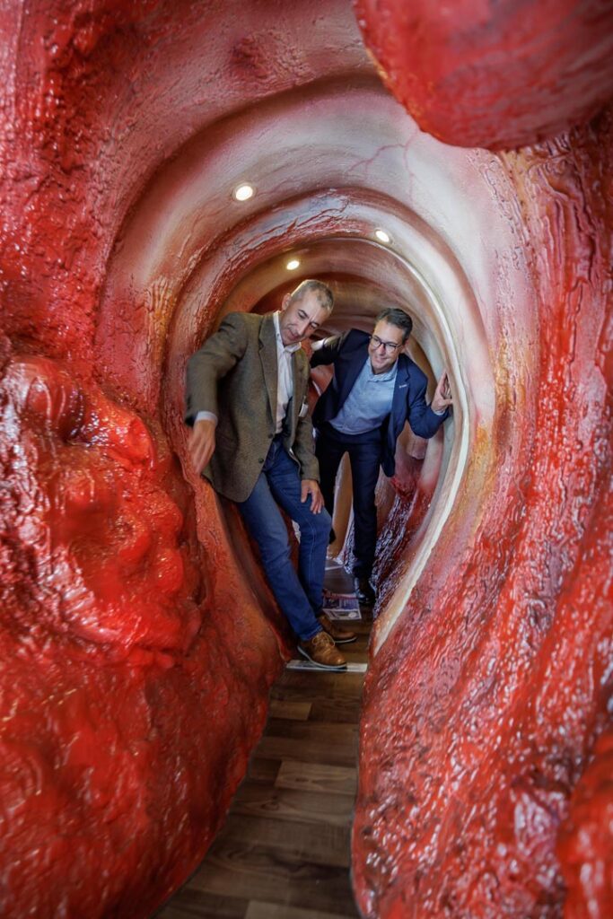 Landrat Dr. Richard Sigel und Gastroenterologie-Chefarzt Dr. Bernhard Fröhlich laufen durch sieben Meter Darm Darstellung.