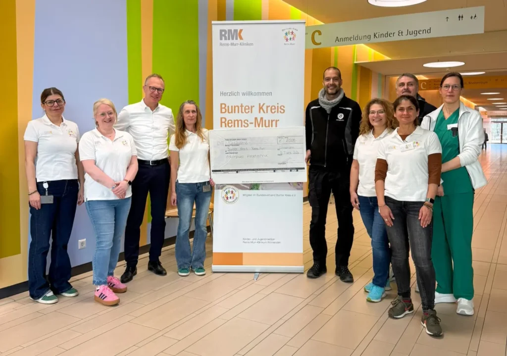 Zwei Mitarbeitende der Firma Astorplast Klebetechnik übergeben Scheck an den Bunten Kreis Rems-Murr